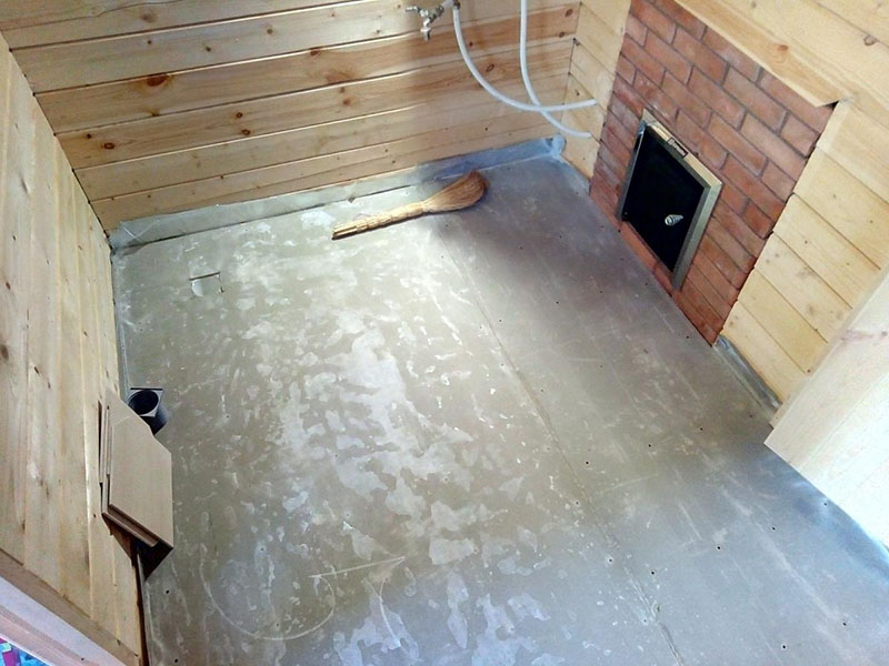 На бетонный пол в бане можно уложить плитку или же собрать деревянные щиты